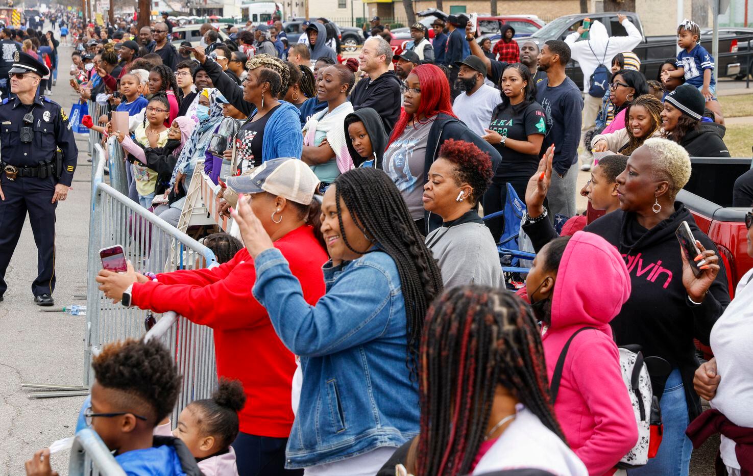 Attendees wave to people during the Martin Luther King Jr. Day Parade in Dallas, Monday,...