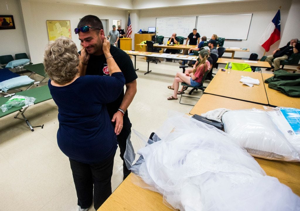 Joyce Brown, left, office manager of the Lumberton Central Fire Station, talks to Firefighter Kyle Parry, who retrieved the wedding dress of his fiancÃ©, Stephanie Hoekstra, not pictured, of Chatham-Kent, Ontario, Canada, from his home, which is flooded as a result of Tropical Storm Harvey on Thursday, August 31, 2017 in Lumberton, Texas. Parry and Hoekstra are supposed to be married on September 10 in Galveston, TX. Parry's home is destroyed, but he was able to retrieve the dress. (Ashley Landis/The Dallas Morning News)