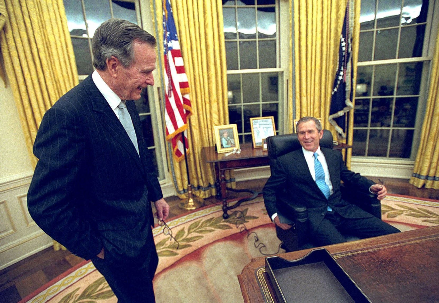2001: President George W. Bush talks to his father, former President George H.W. Bush, as he...