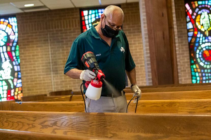 Polo Herrera sprays a sanitizer on pews at the St. Patrick Catholic Church in the Lake...