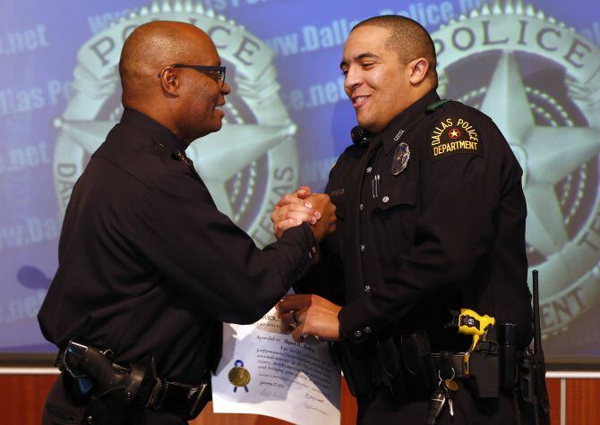 Dallas Police Chief David Brown (left) congratulated Officer Ryan Mabry, one of three...