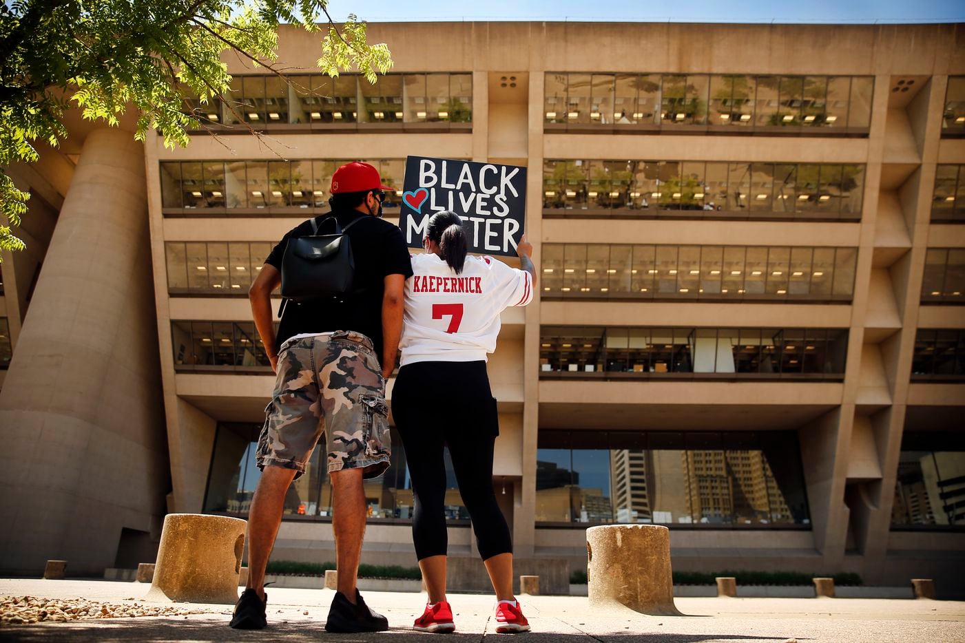 Protestors Xavier Reyes (left) and his girlfriend Aprille Peterson raise their Black Lives Matter painting toward Dallas City Hall during a Silent Protest and Mourning rally, Thursday, June 4, 2020. Aprille is wearing Xavier's Colin Kaepernick jersey, one he got before the kneeling protest and has worn ever since. No one spoke as they stood in solidarity with signs, protesting the in-custody death of George Floyd in Minneapolis.