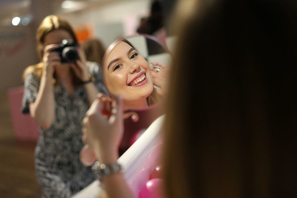 Visitors take and pose for "selfie" photographs at The Selfie Factory in Westfield London...