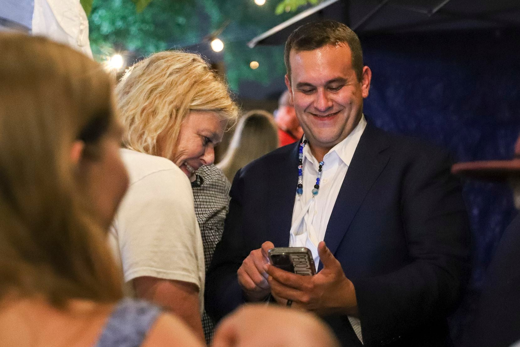 Adam Bazaldua, Dallas City Council District 7 candidate, and his mother Pam Bradford, looked at results during an election night watch party at Eight Bells Alehouse on May 1. (Elias Valverde II/Special Contributor)