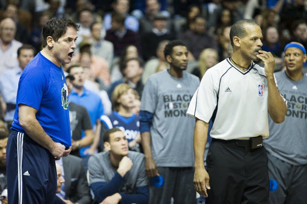 Dallas Mavericks owner Mark Cuban get in the ear of referee Eric Lewis after a foul was...
