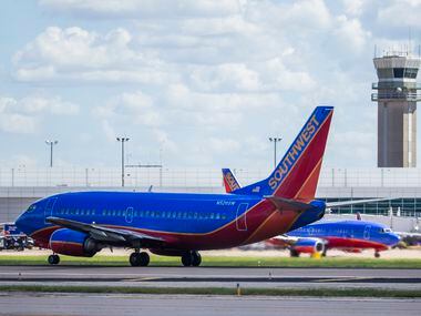 A Southwest Airlines airplane takes off as others remain parked at terminals while computer...