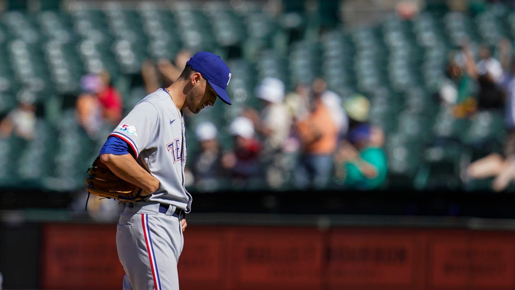 Texas Rangers relief pitcher Brett Martin reacts after he gave up a solo home run to Oakland...