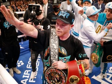 Boxers Canelo Alvarez celebrates with his belts after defeating Billy Joe Saunders in the eighth round of their super middleweight title fight at AT&T Stadium in Arlington, Saturday, May 8, 2021.  Sauders couldn't go on because he unsustained an eye injury and couldn't see.