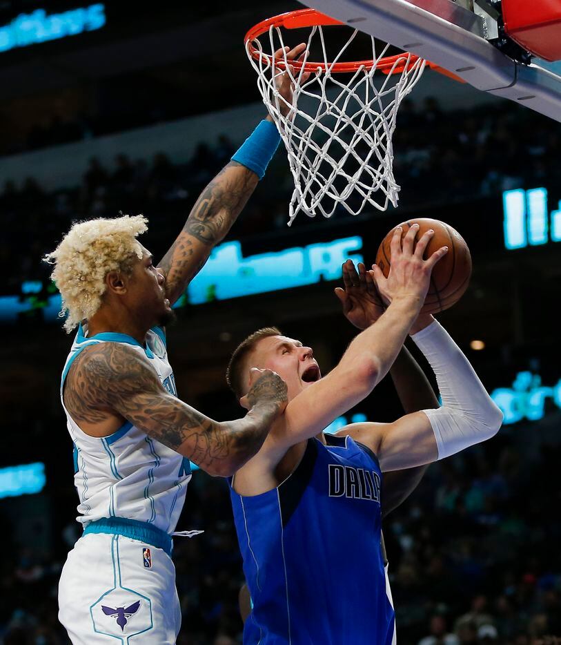 Dallas Mavericks center Kristaps Porzingis (6) attempts a layup as Charlotte Hornets guard Kelly Oubre Jr., left, defends during the second half of an NBA basketball game in Dallas, Monday, December 13, 2021. Dallas won 120-96. (Brandon Wade/Special Contributor)
