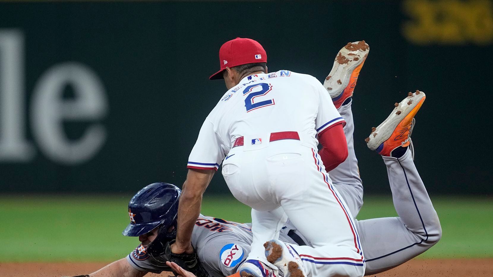 Houston Astros' Chas McCormick, bottom, is tagged out trying to steal second by Texas...