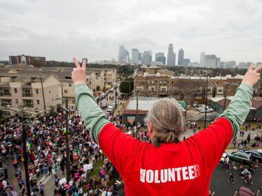 Herb Keener waves to participants reaching the end of the Dallas Women's March from atop the...