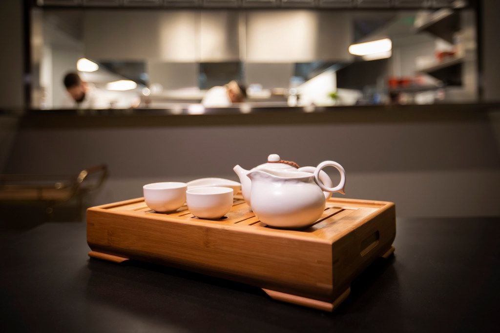 During tea service at Fine China, servers "bloom" the tea by pouring out the first bit of...