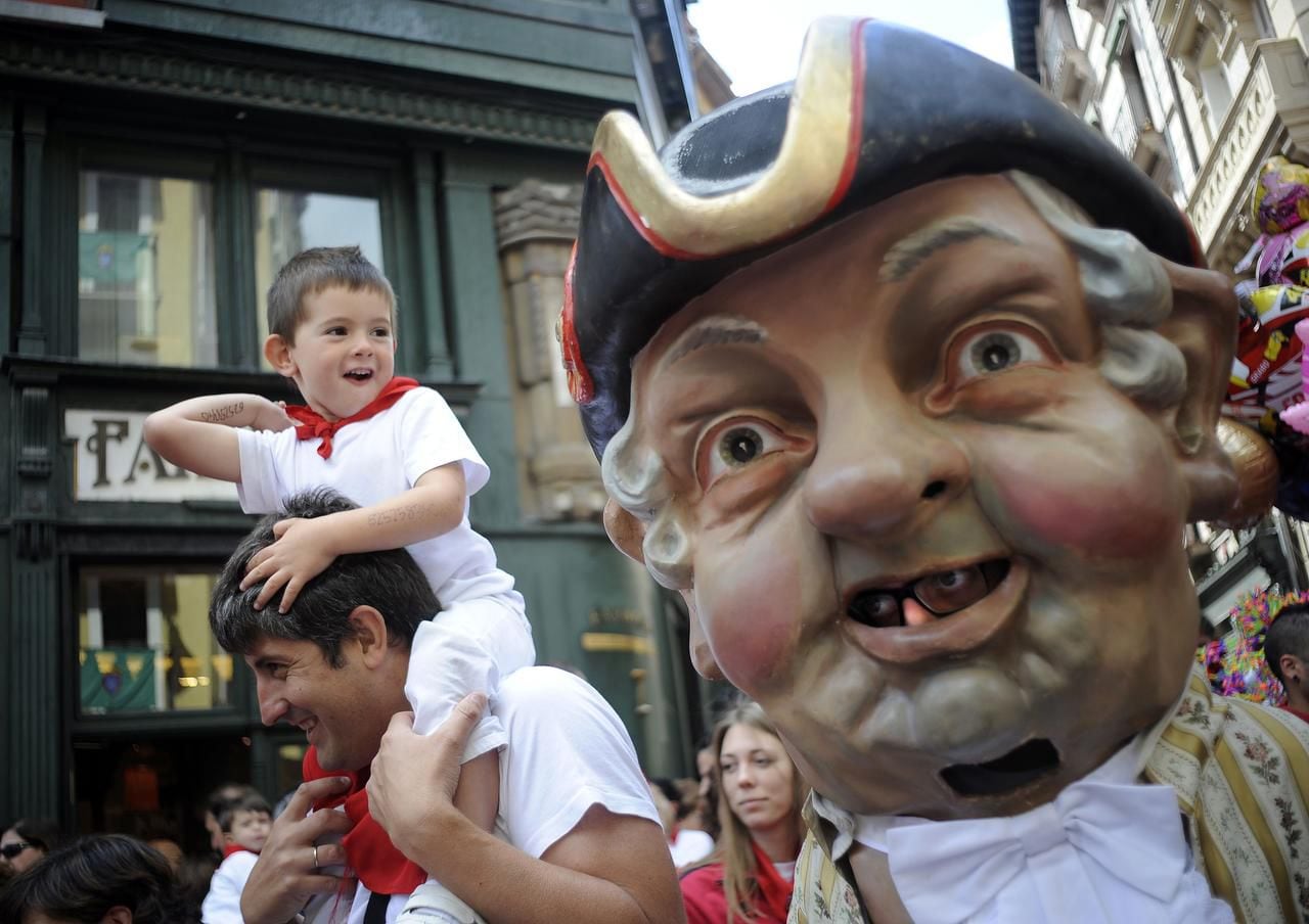 
Cabezudos (Big-Heads) chase parents and children in the crowds during the children’s...