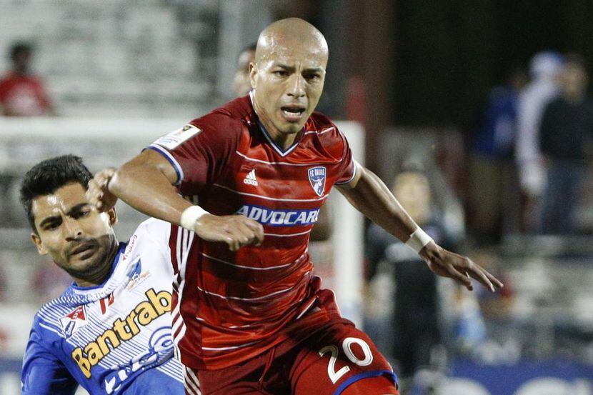 Club Deportivo Suchitepequez striker Julian Lalinde (15) trips FC Dallas midfielder Juan...