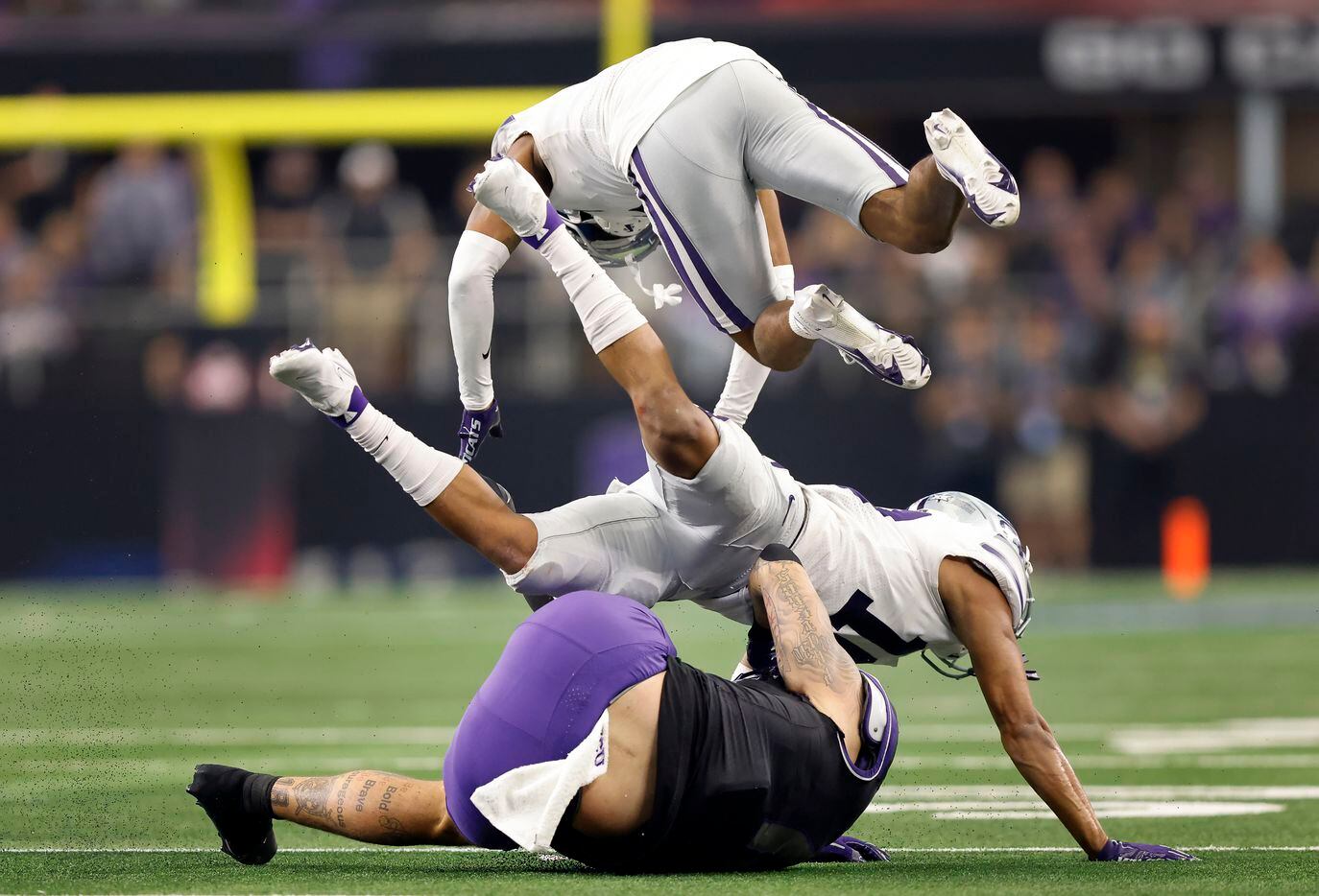 Kansas State Wildcats safety Josh Hayes (1) and cornerback Jacob Parrish (10) go flying over...