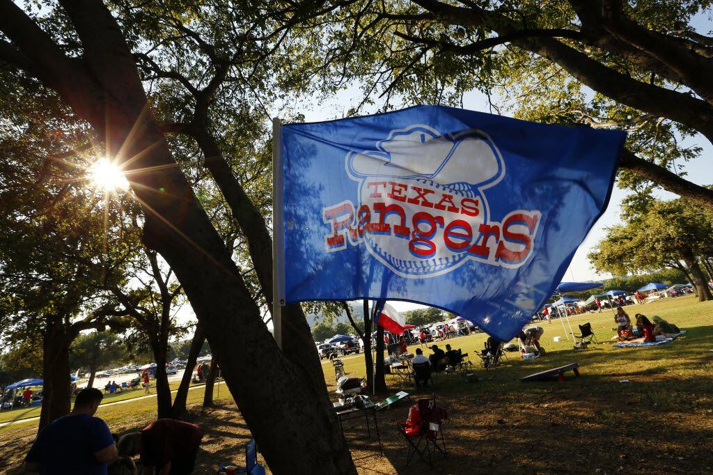 A Texas Rangers flag bears the original team logo as fans tailgate before the ALDS Series game between Texas Rangers and Toronto Blue Jays at Globe Life Park in Arlington, Sunday October 11, 2015.