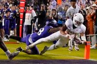 Texas running back Jonathon Brooks, right, dives into the end zone in front of TCU safety...