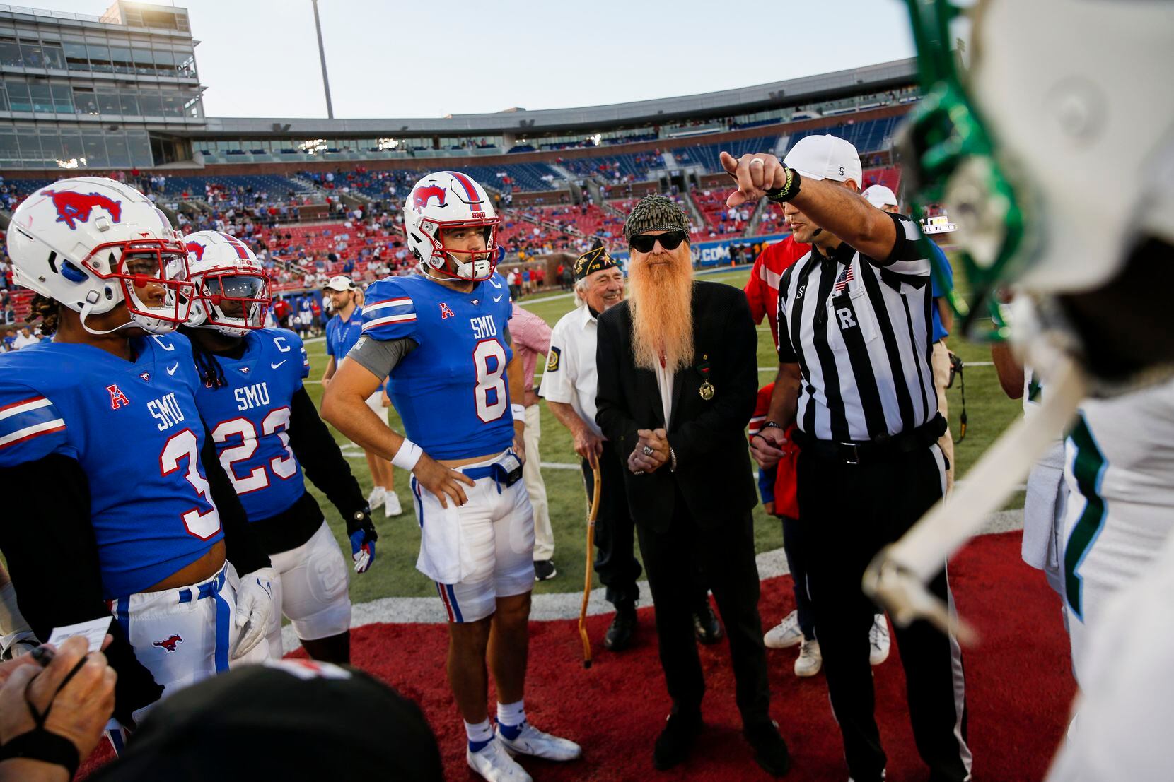 ZZ Top's Billy Gibbons (with beard) does the coin toss before the start of a game between...