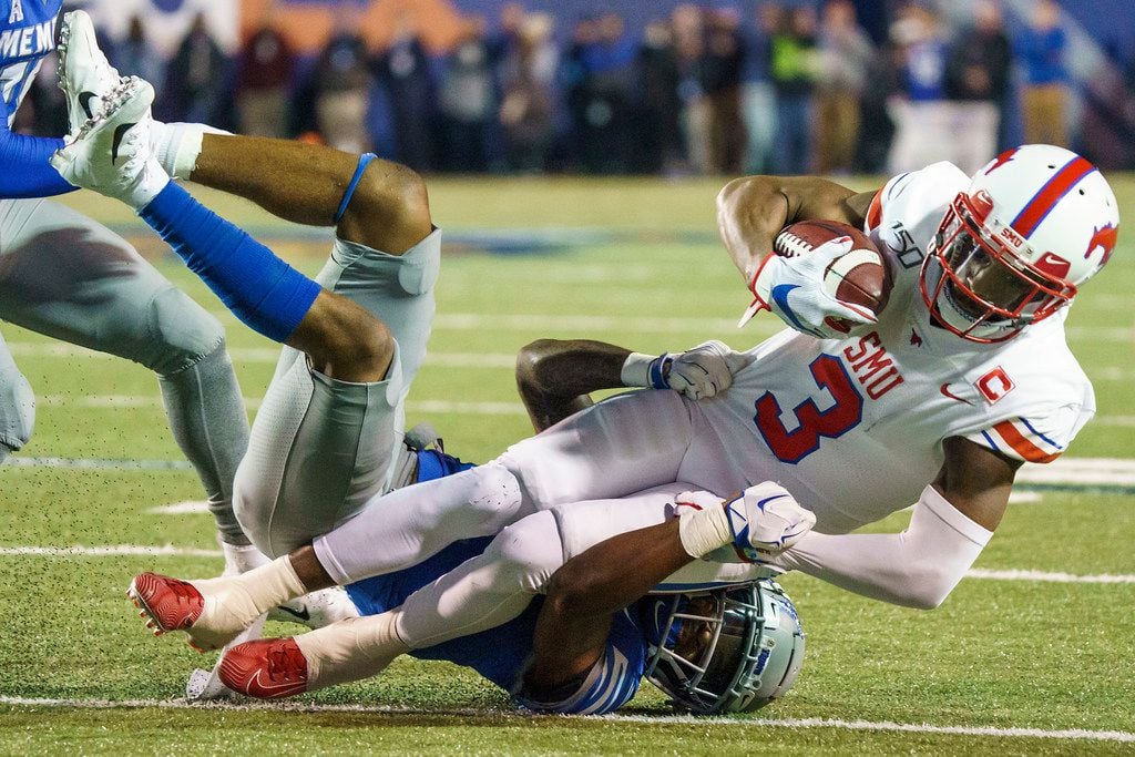 SMU wide receiver James Proche (3) in brought down by Memphis defensive back T.J. Carter (2)...