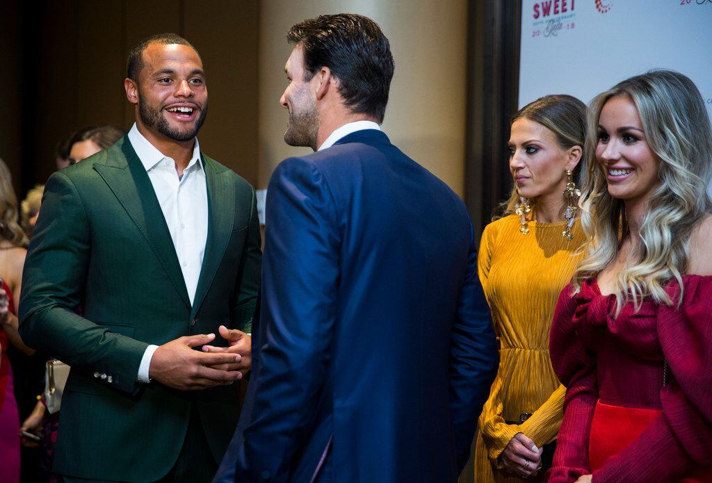 Dallas Cowboys quarterback Dak Prescott, left, talks with former quarterback Tony Romo during The Children's Cancer Fund Gala on Friday, April 27, 2018 at Hyatt Regency Dallas. At right are co-chairs of the event Hollie Siglin and Candice Romo. (Ashley Landis/The Dallas Morning News)
