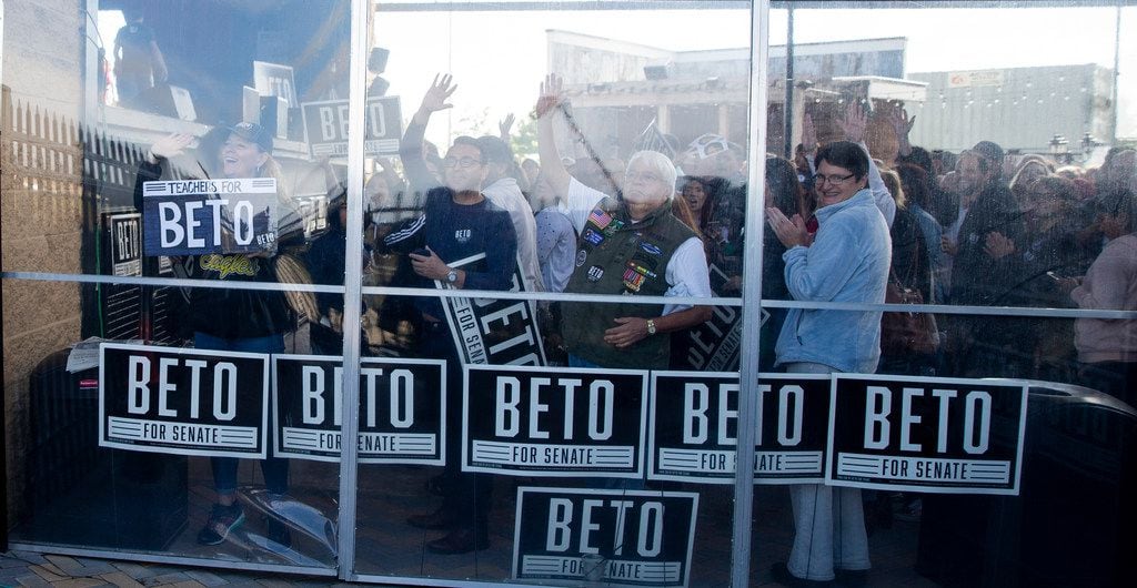 Supporters wave as Congressman Beto O'Rourke arrives to campaign at Lava Cantina in The...