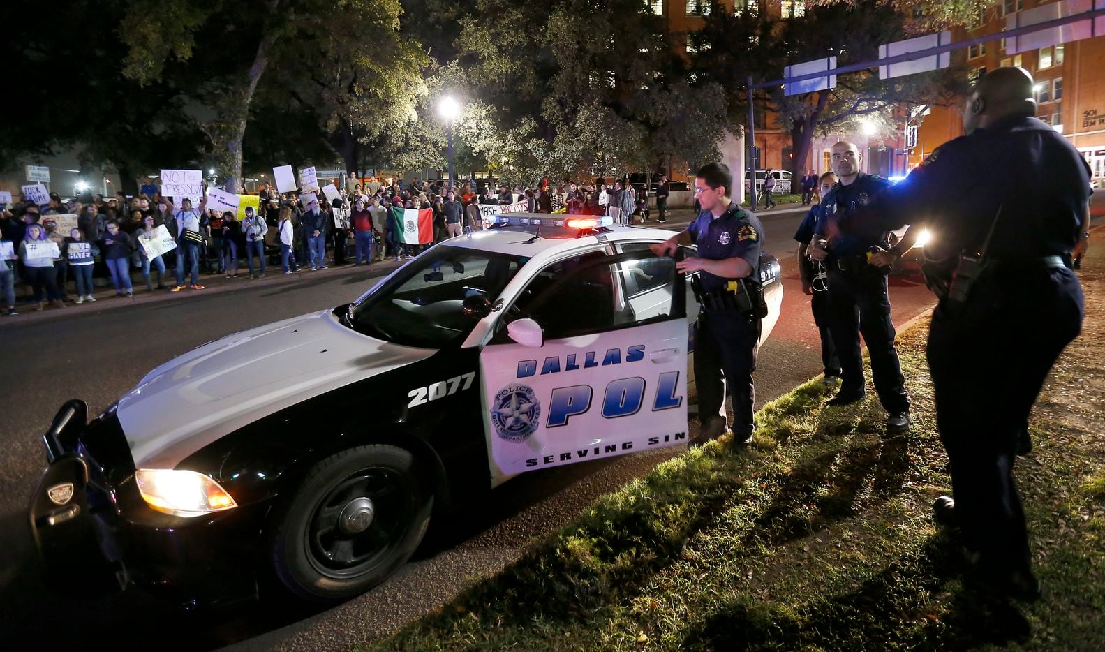 Dallas Police officers gather near protesters against President-elect Donald Trump on Elm...