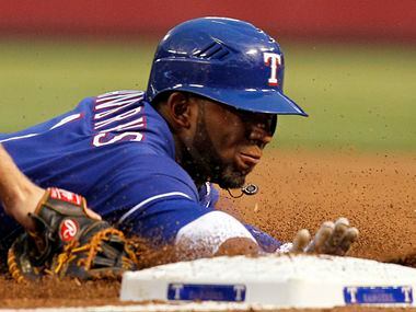 Texas Rangers Elvis Andrus dives back to first just under the tag by Los Angeles Angels...