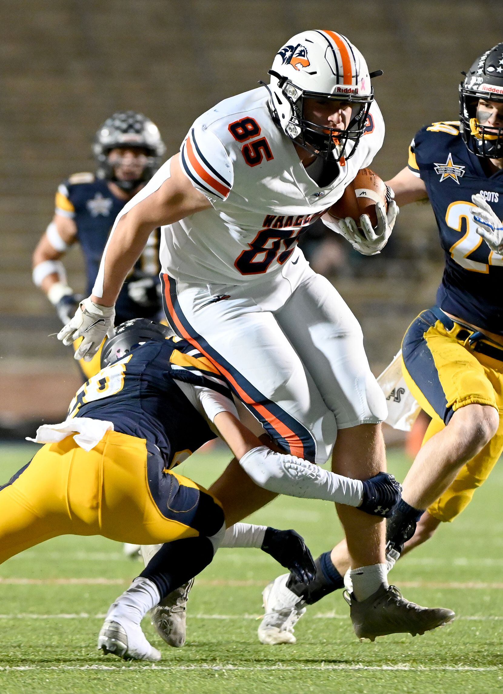 Wakeland's Tripp Riordan (85) is tackled by Highland Park's J.T. Withers (26) attempt by in...