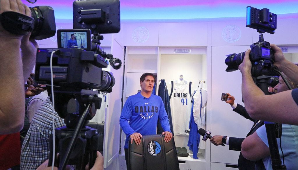 Dallas Mavericks owner Mark Cuban talks with the media in front of Dirk Nowitzki's locker...