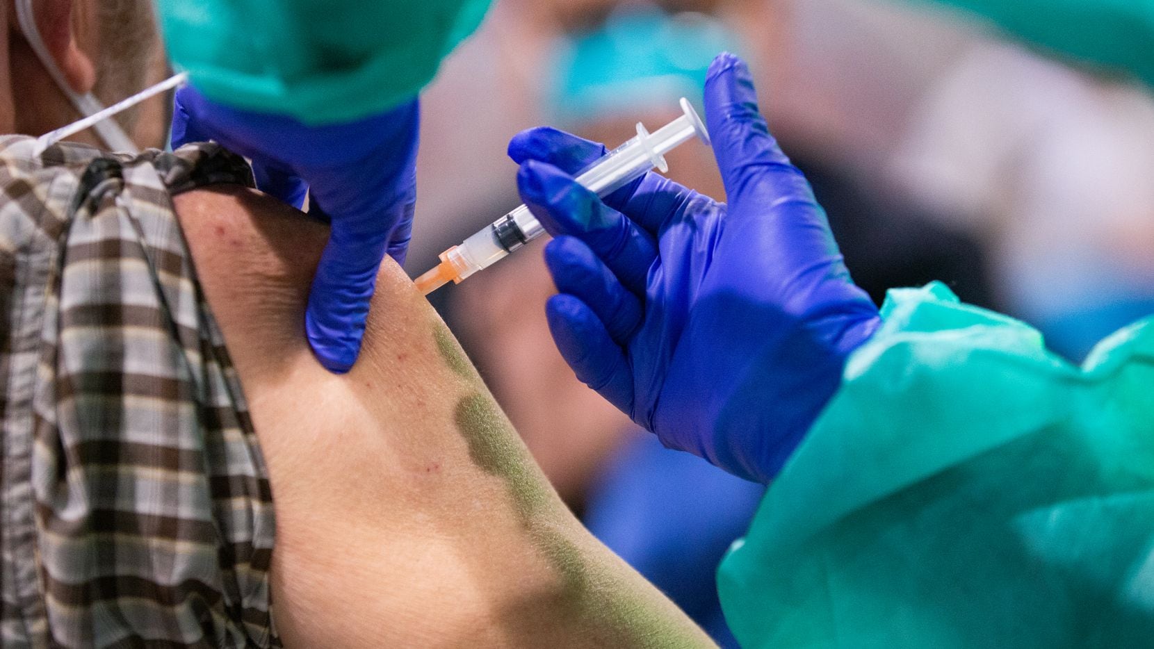 A man is injected with the COVID-19 vaccine at Fair Park in Dallas on Wednesday, Feb. 2, 2021.