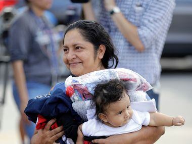 Immigrant Maria Del Carmen Barrios, from Guatemala, carries her six-month-old son Jose as...