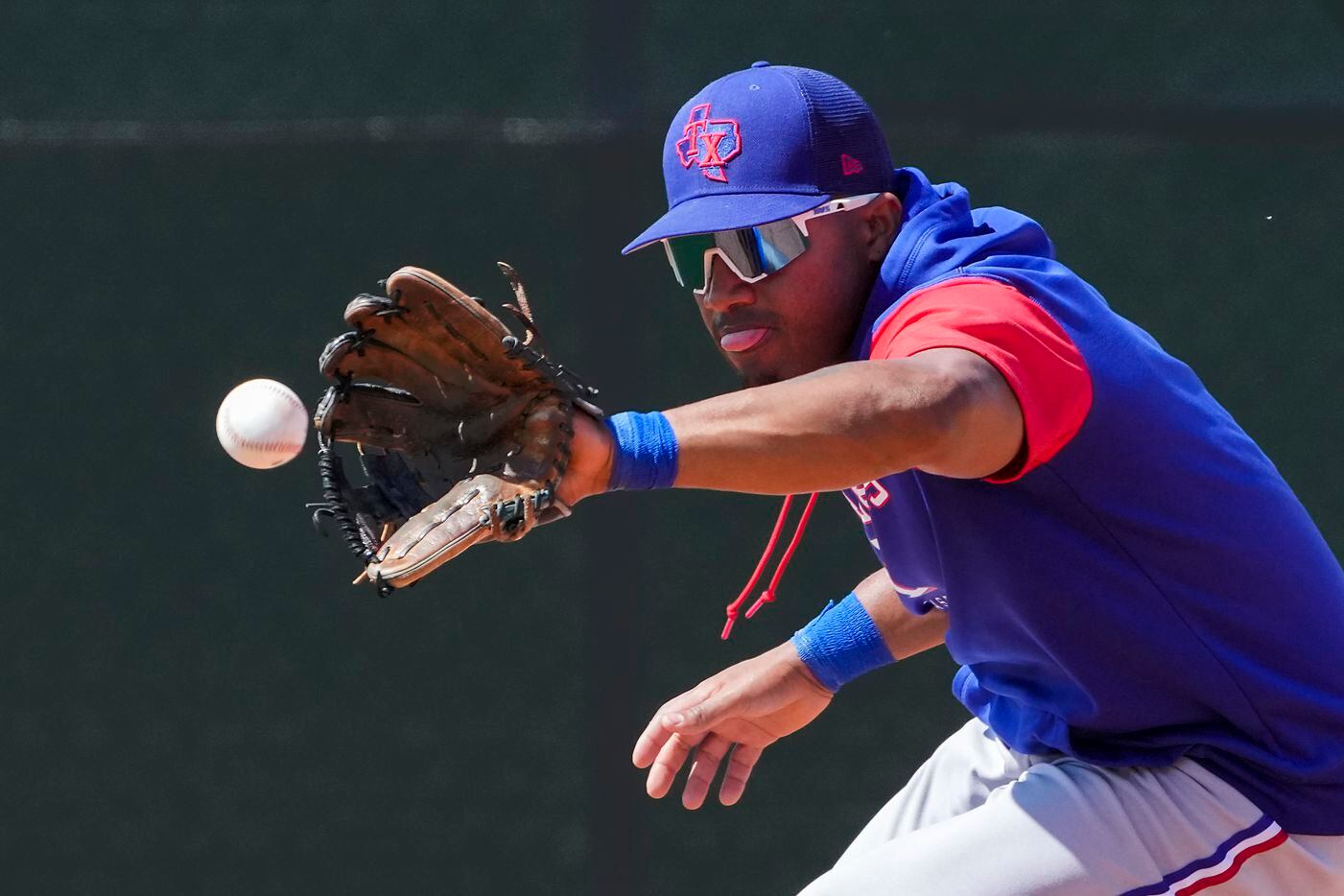 Texas Rangers infielder Andy Ibáñez fields a grounder during a spring training workout at...