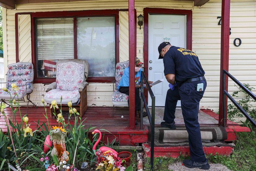 Dallas Fire-Rescue officer Corey Nix filled out some paperwork with Albert Garza, 75, after...