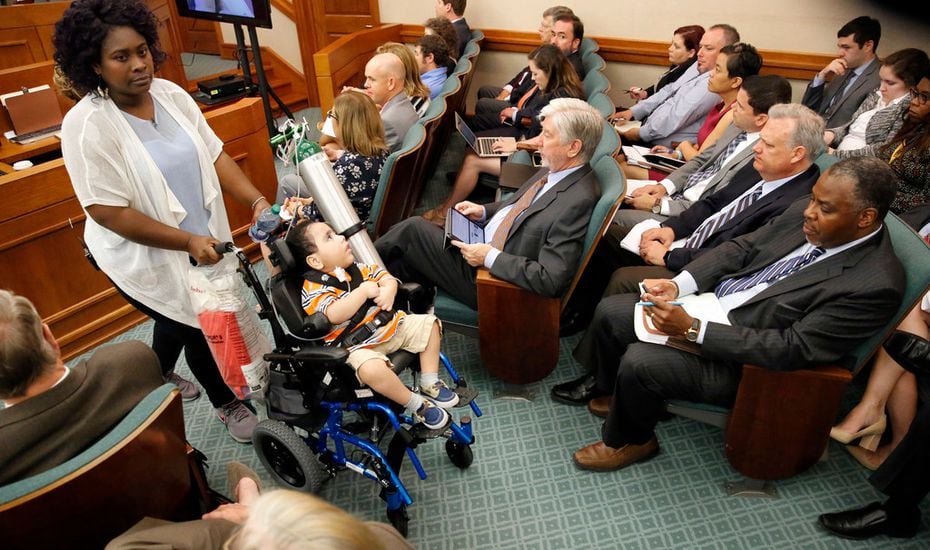 Mesquite mother Linda Badawo (left) pushed her medically fragile son, D'ashon Morris, past representatives of Superior HealthPlan (seated right) after testifying before the Texas House General Investigating and Ethics Committee in Austin on Wednesday. 