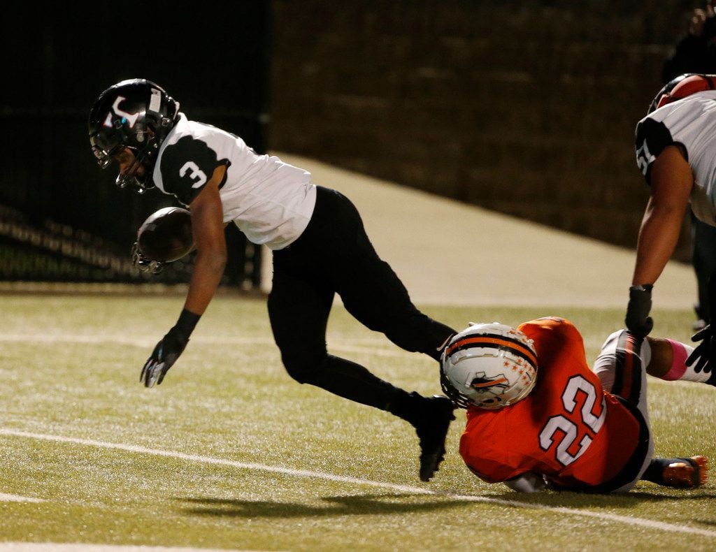 Trinity running back Zechariah Moore (3) scores a touchdown as he is tackled by Haltom's...