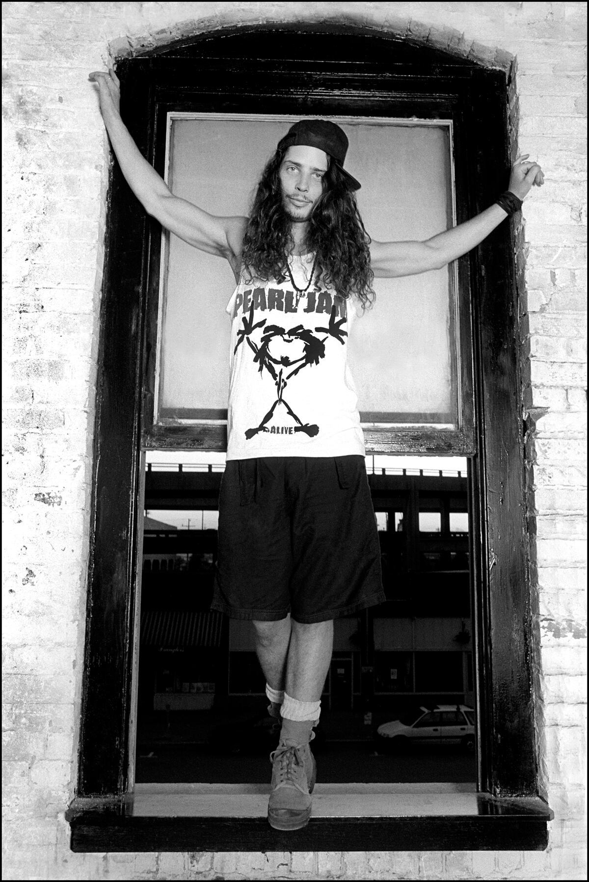 Chris Cornell, clad in a Pearl Jam shirt, stands in the window of photographer Karen Mason...
