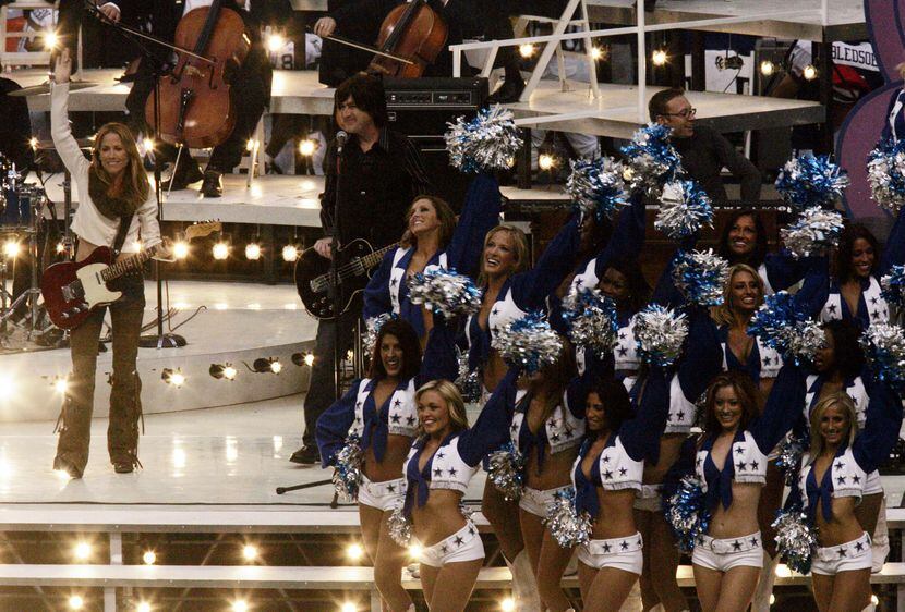 Sheryl Crow shares the stage with the Dallas Cowboys cheerleaders during her Thanksgiving...
