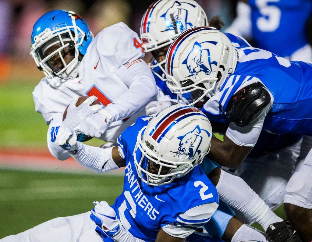 Skyline running back Qualon Farrar (4) is tackled by Duncanville defenders during the first...