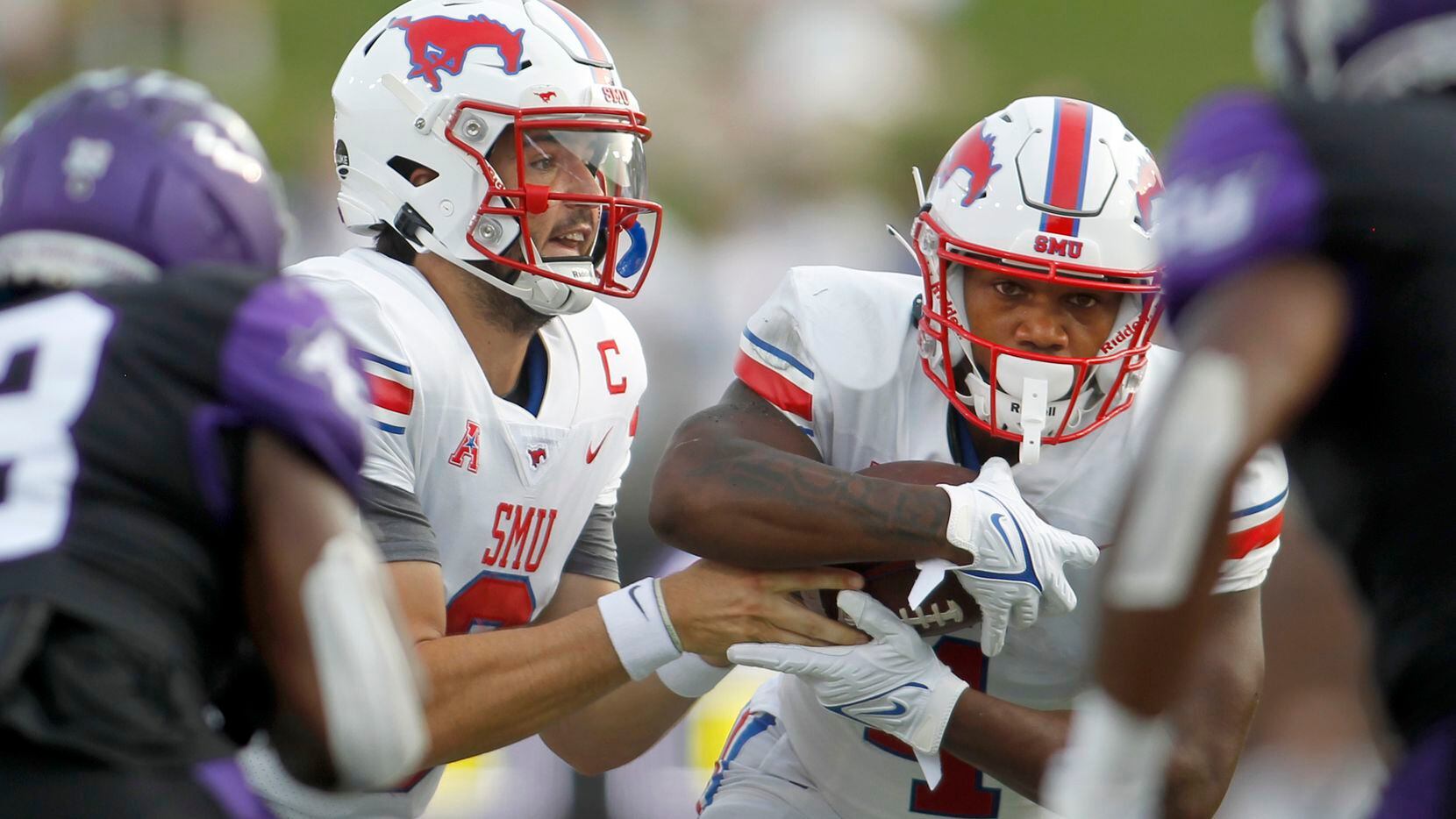 SMU quarterback Tanner Mordecai (8) hands off to running back Tre Siggers (4) during a first...