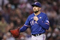 Texas Rangers starting pitcher Nathan Eovaldi heads back to the dug out after getting out of...