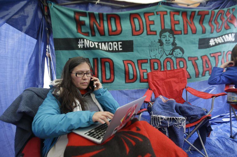 La activista Maru Mora Villalpando habla por teléfono mientras revisa su correo electrónico,...