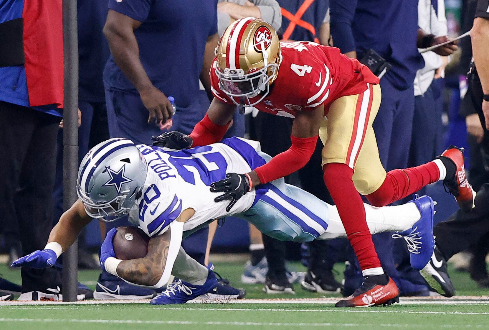 Dallas Cowboys running back Tony Pollard (20) is hit from behind by San Francisco 49ers...