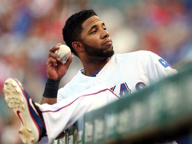 Texas shortstop Elvis Andrus throws a ball to a fan from the dugout before the Minnesota...
