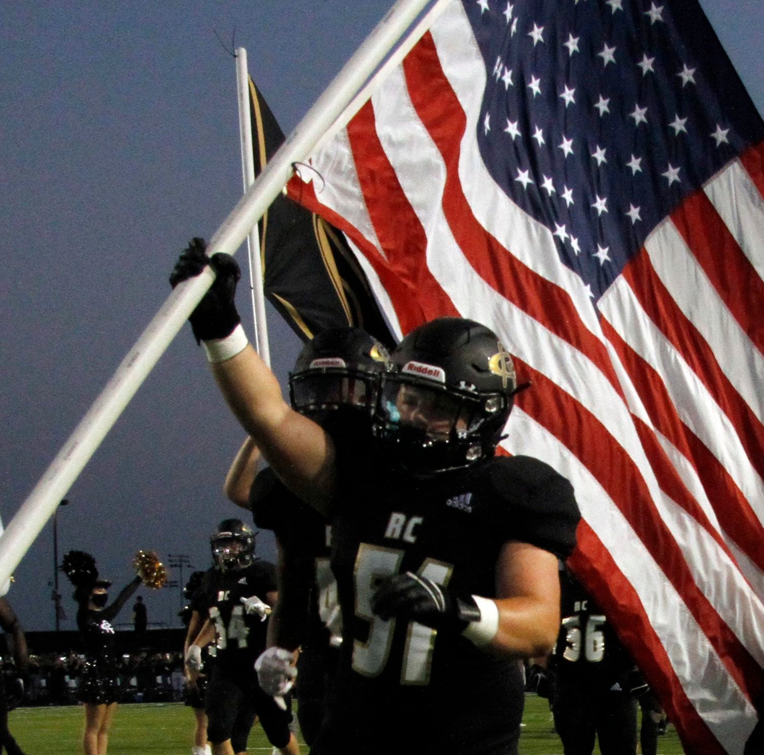 Royse City defensive lineman Griffin Merillat (51) carries the american flag onto the field...