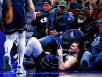 Dallas Mavericks guard Luka Doncic, center bottom, reacts after drawing a foul during the...