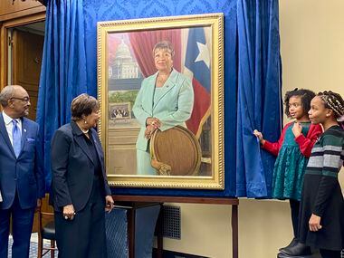 Rep. Eddie Bernice Johnson, D-Dallas, center, looks at her official portrait, with family,...