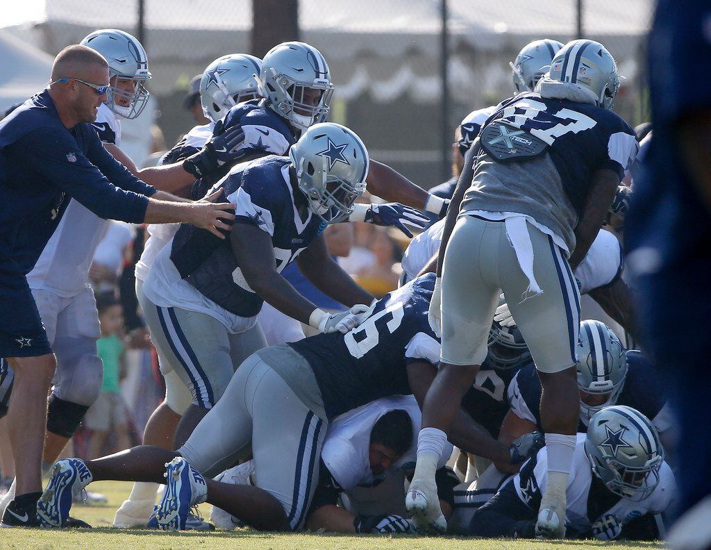 Dallas Cowboys players fight during the afternoon practice at the training camp in Oxnard,...