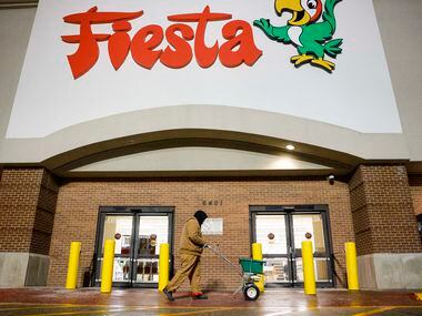Cesar Montoya of Integrity Porter and Services salts a walkway outside a Fiesta Mart in...