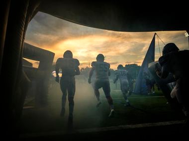 Frisco Lone Star players take the field to face Highland Park in a high school football game as the sun sets on Highlander Stadium in University Park.