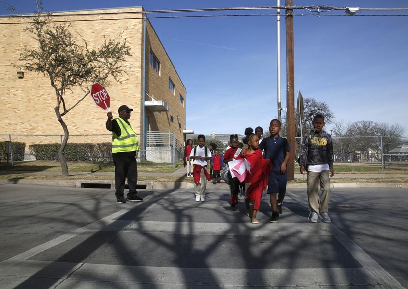 Un grupo de estudiantes cruza la calle en las afueras de la escuela J. W. Ray Learning...
